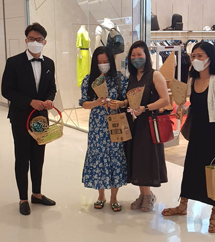 Nhân viên trung tâm thương mại tặng hoa cho khách hàng nữ tại Crescent Mall, Quận 7, Thành phố Hồ Chí Minh